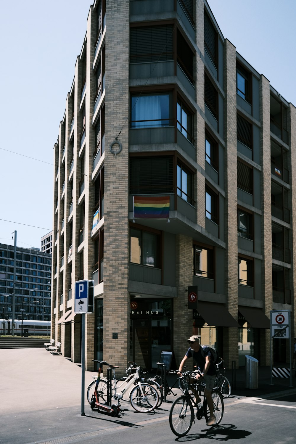 Un par de personas montando en bicicleta al lado de un edificio