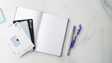 a few pens and notebooks on a table