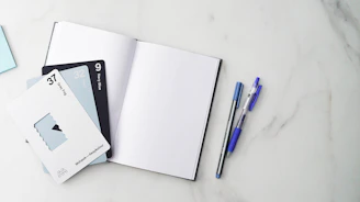 a few pens and notebooks on a table
