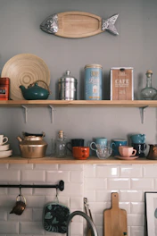 a kitchen with a shelf full of dishes and pots