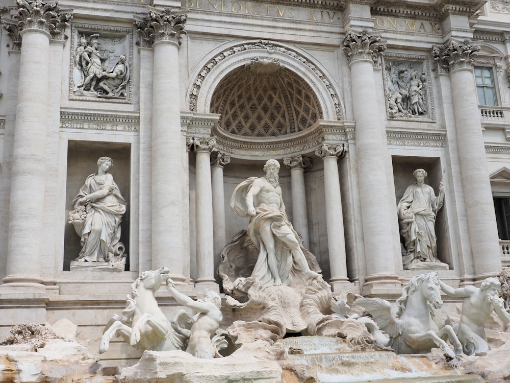 un grupo de estatuas frente a la Fontana de Trevi