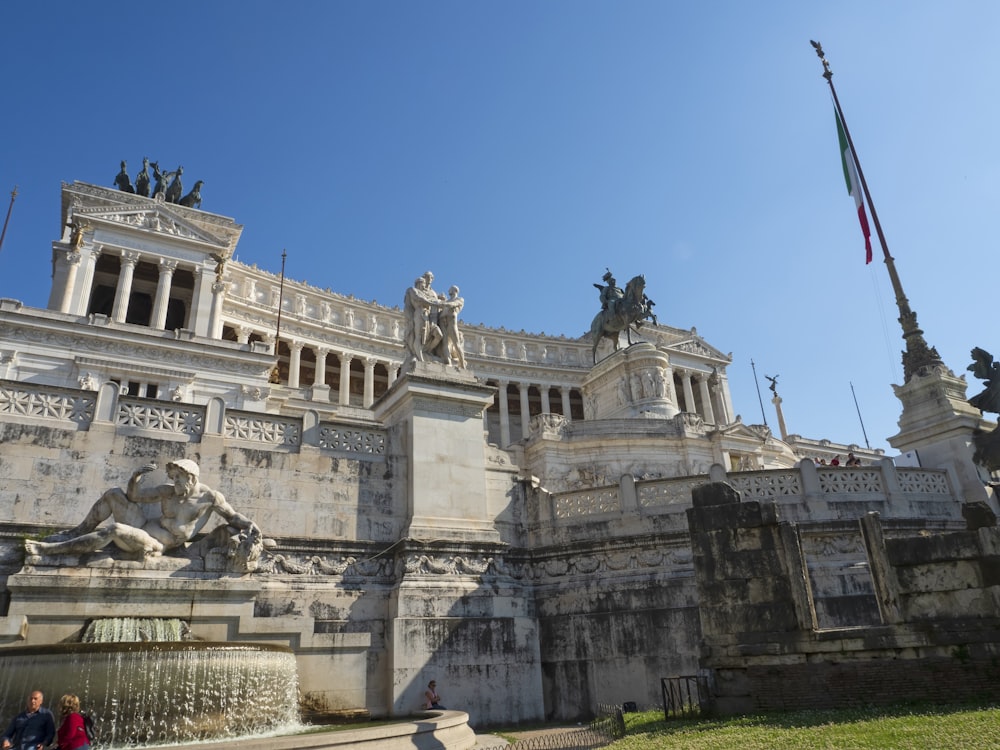 a stone building with statues and a flag on top