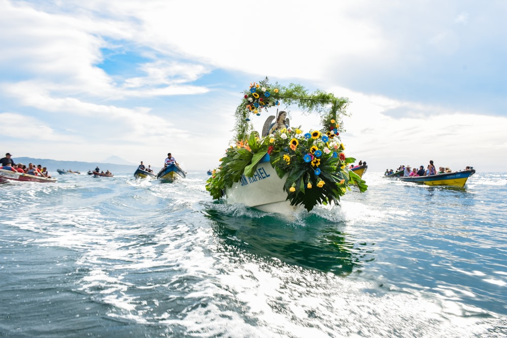 a group of people in boats with flowers on a body of water