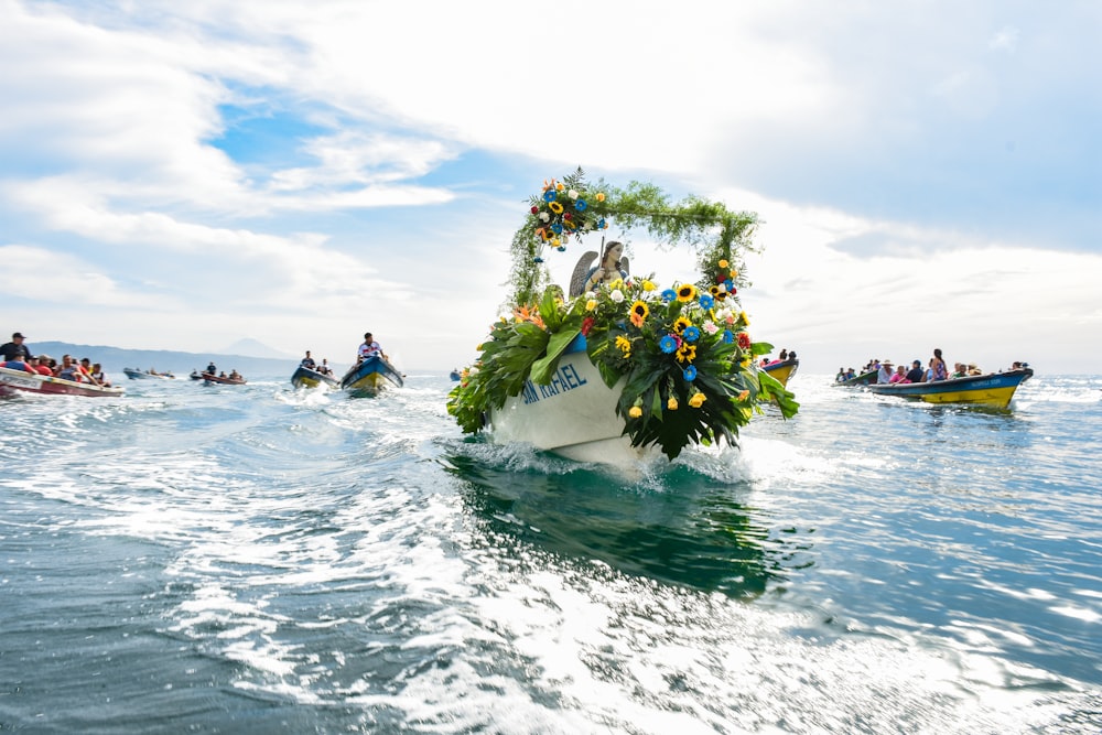 un gruppo di persone in barca con fiori su uno specchio d'acqua