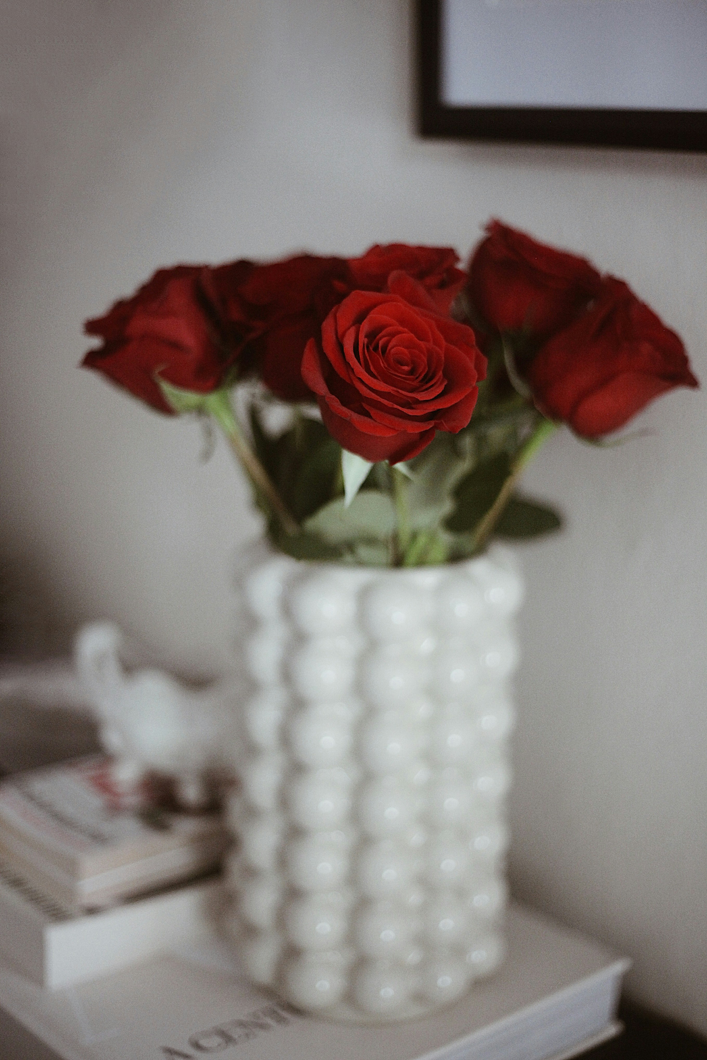 Un jarrón con rosas rojas