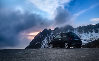 A professional taxi parked on a highway with mountains in the background.