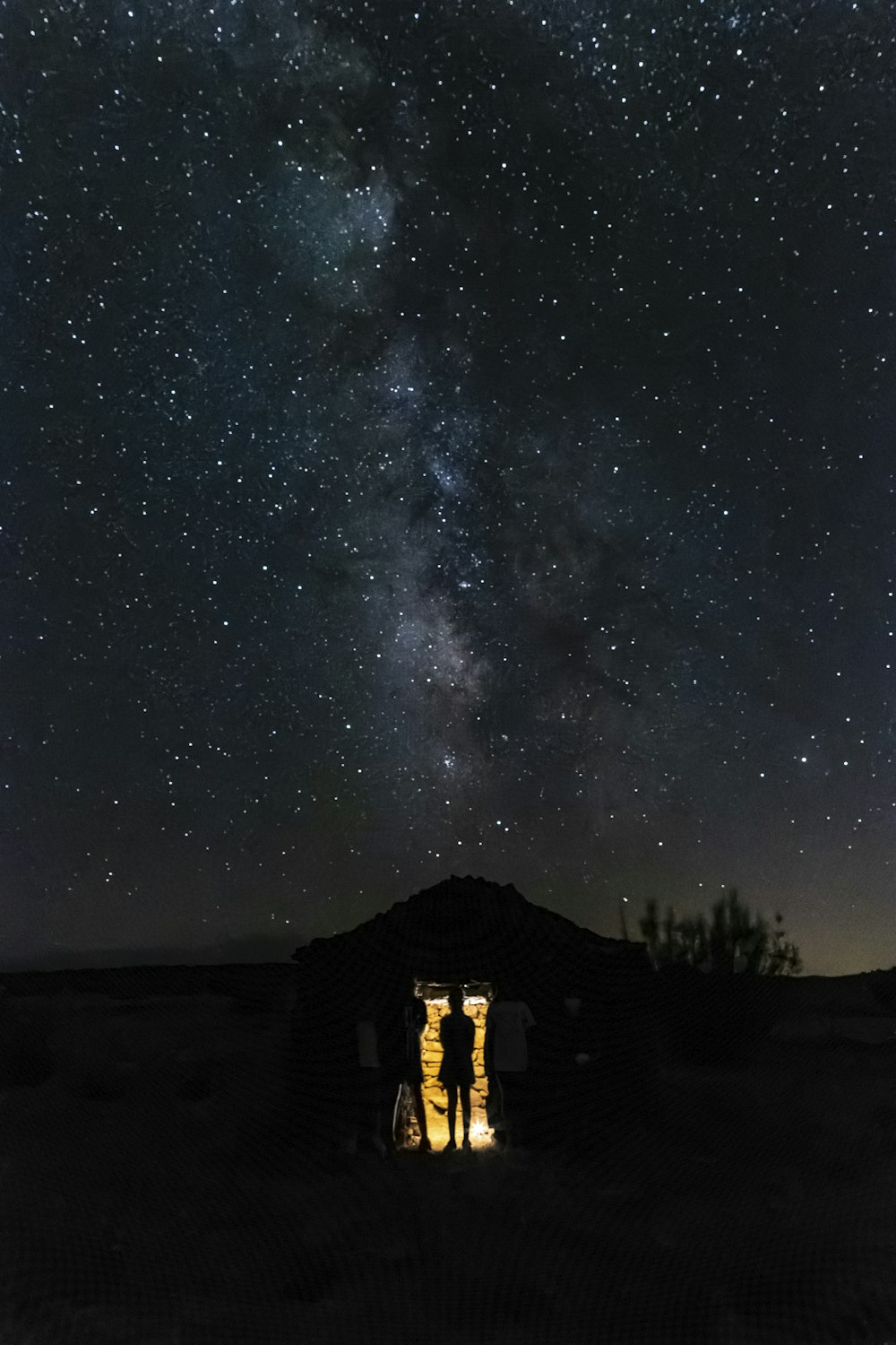a group of people standing in front of a house under a starry sky