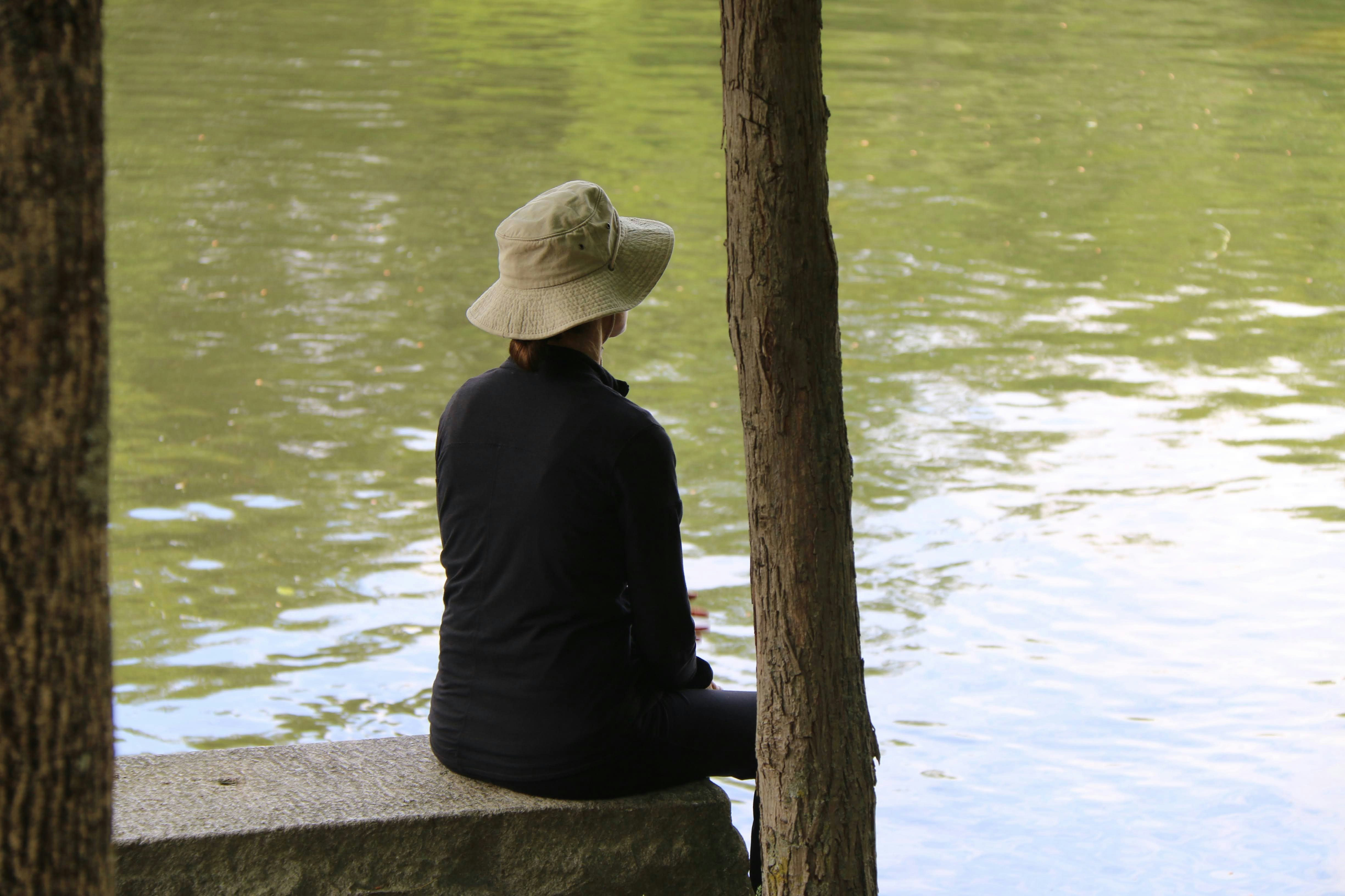 a person sitting on a bench looking at the water