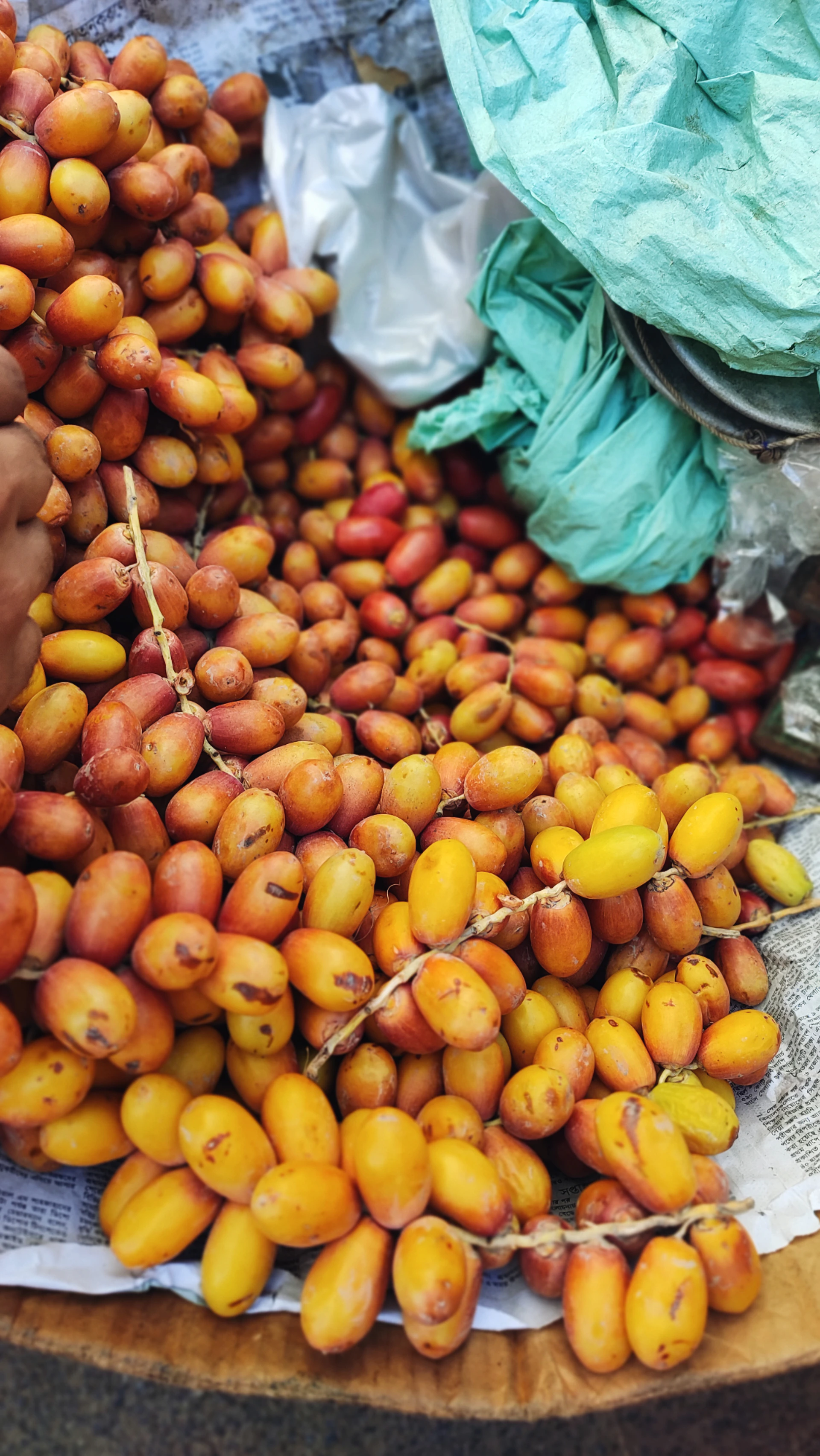 A flowing stream of dates being sorted and packed in a traditional wooden crate, with hands in motion arranging the fruit.