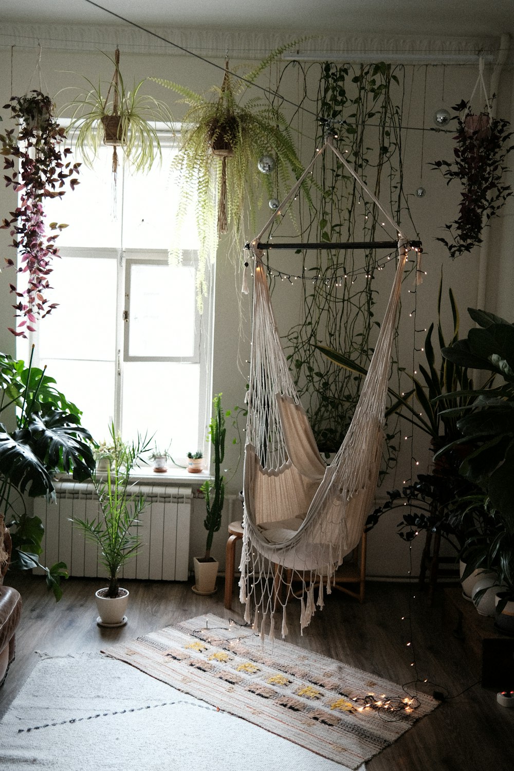 a skeleton from a rope in a room with plants