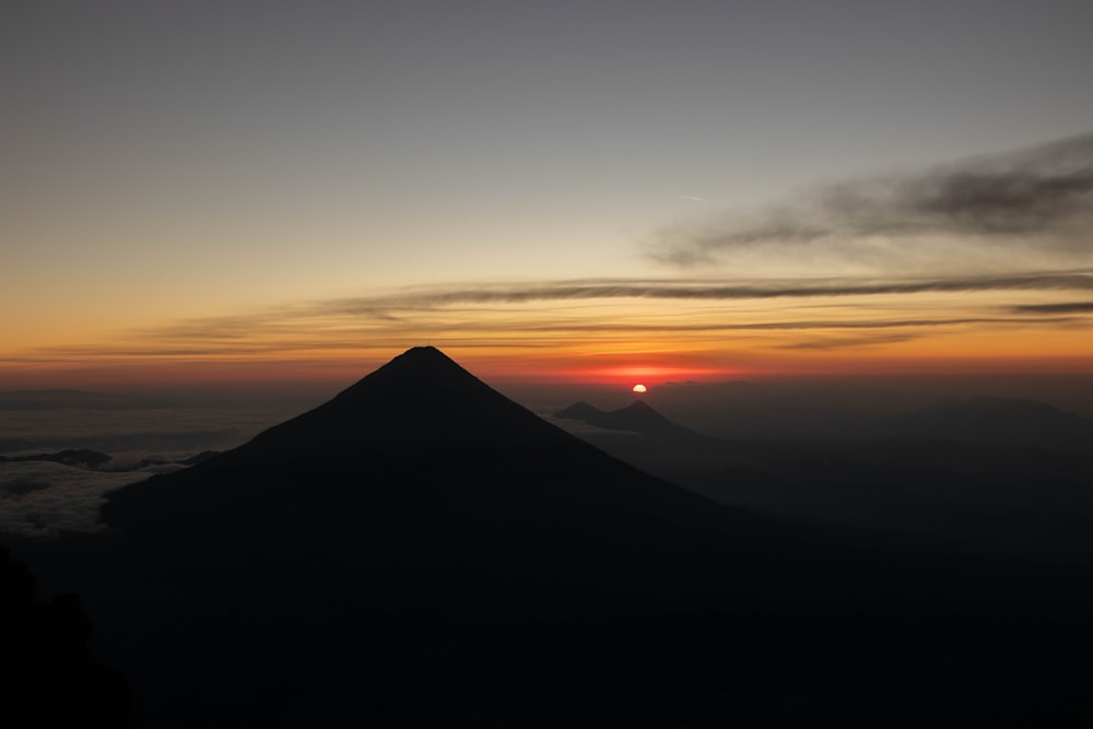 a mountain with a sunset in the background