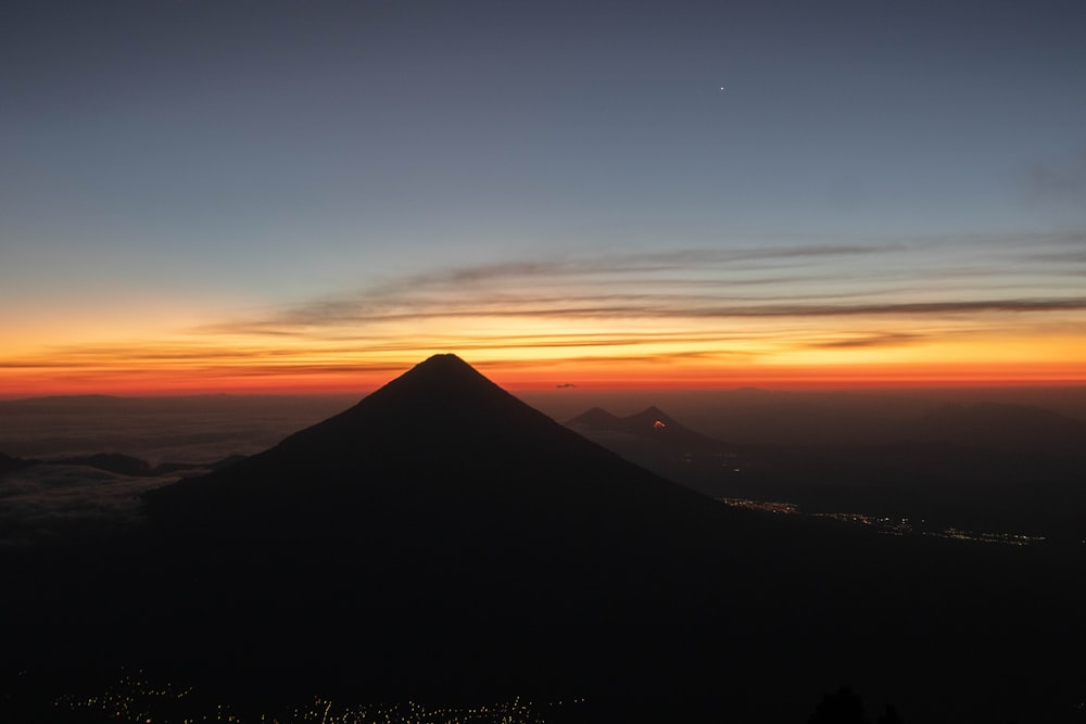 a mountain with a sunset in the background