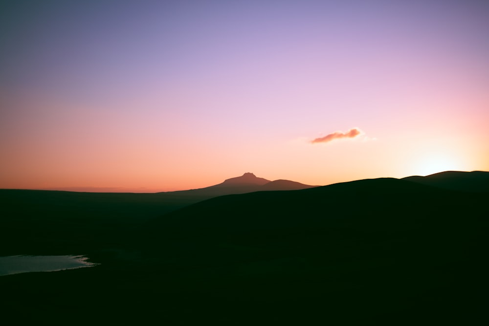 a mountain with a sunset in the background