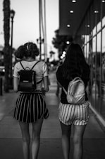 two women walking down a sidewalk