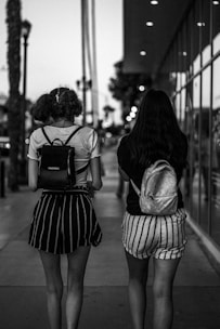 two women walking down a sidewalk