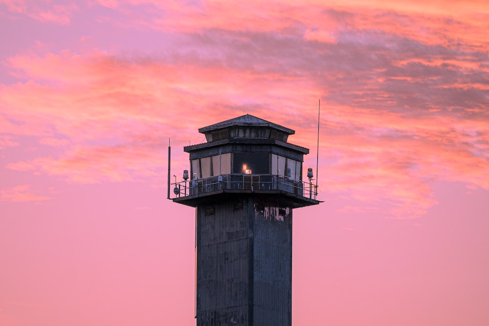 a lighthouse with a pink and blue sky