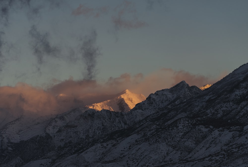 a snowy mountain with clouds