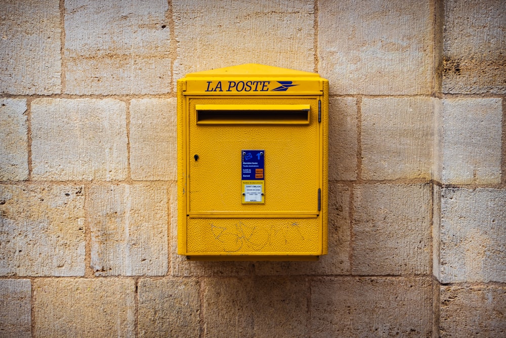 Una caja amarilla en una pared de ladrillo