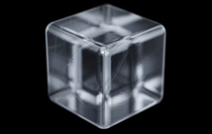 Hands holding a transparent cube with mathematical symbols floating inside.