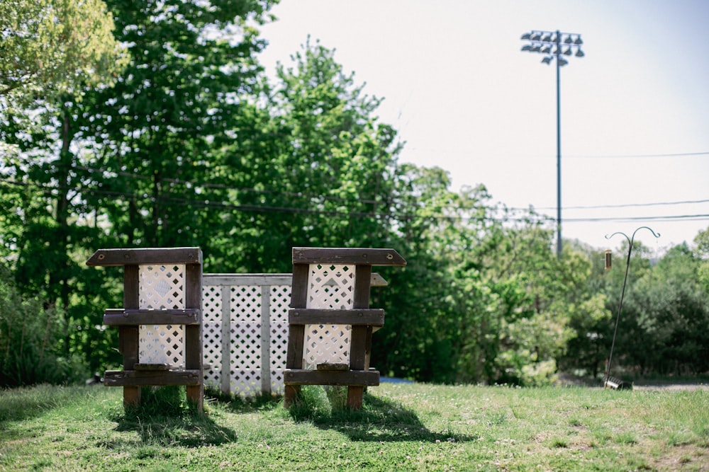 a couple of wooden benches sit in a grassy area