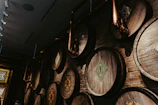 An atmospheric view of a shadowed distillery room with copper stills glowing softly under low light.