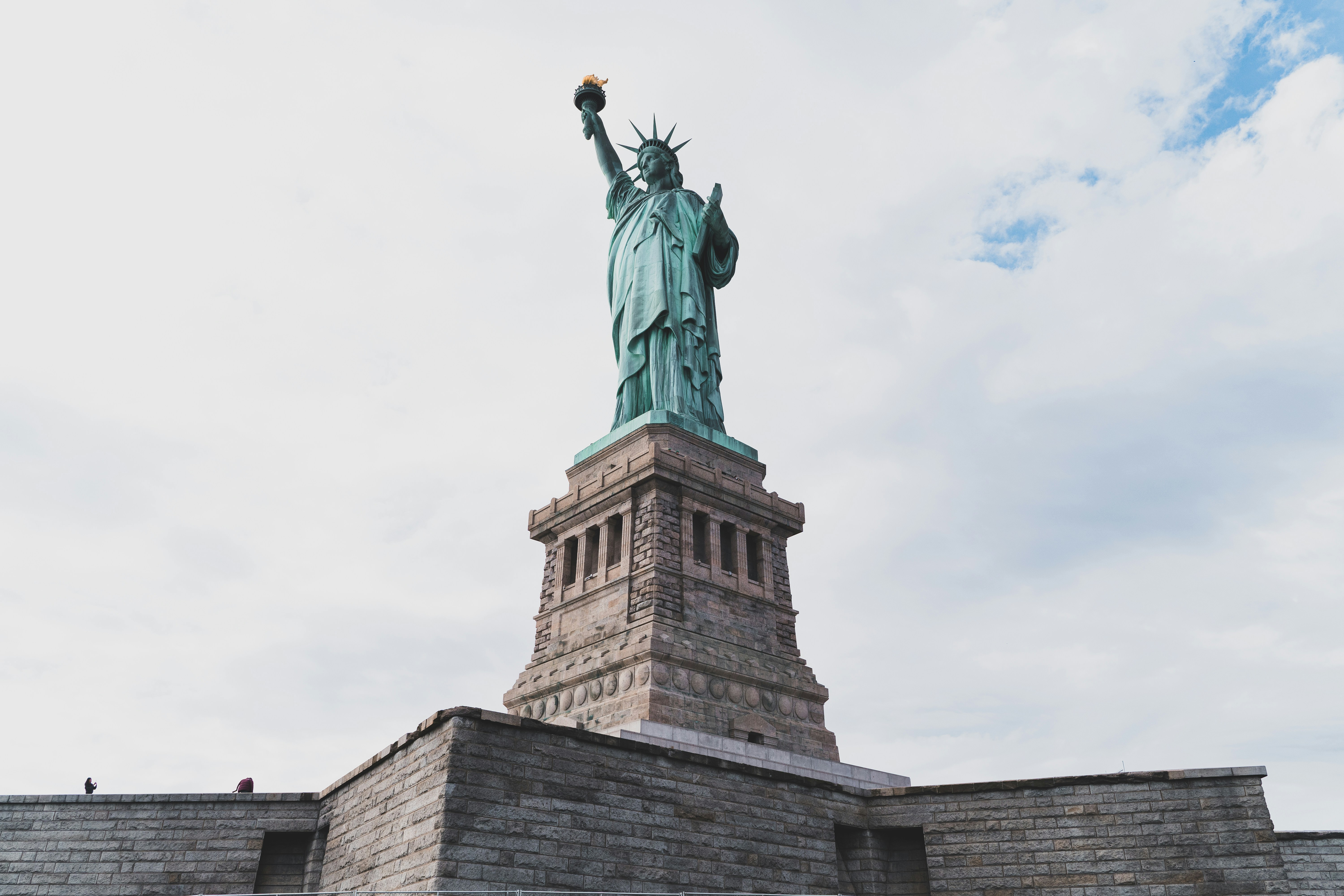 a statue of a person holding a torch on a brick building