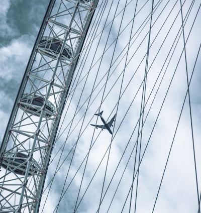 a plane flying over a ferris wheel