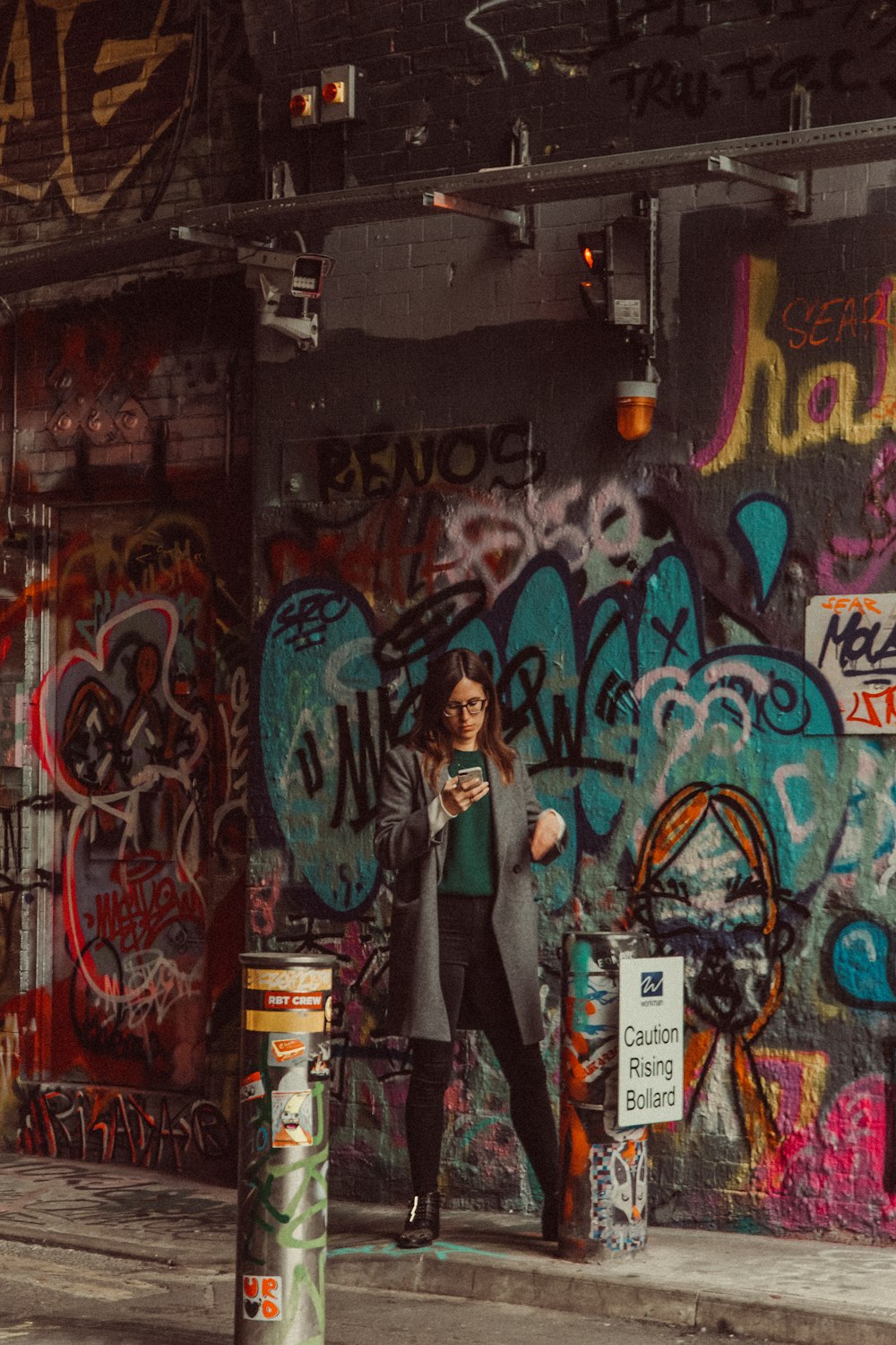 a person standing in front of a wall covered in graffiti