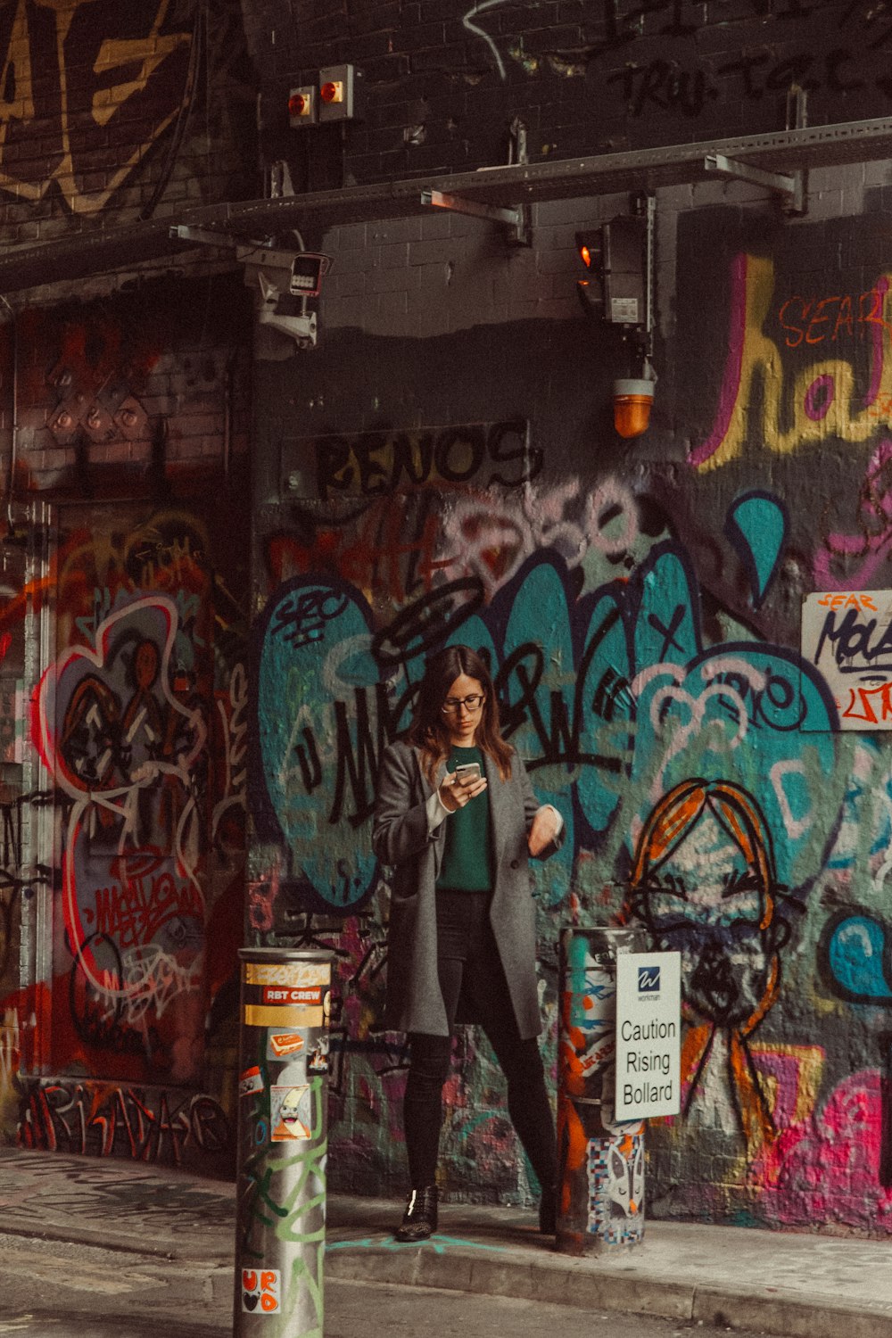une personne debout devant un mur couvert de graffitis