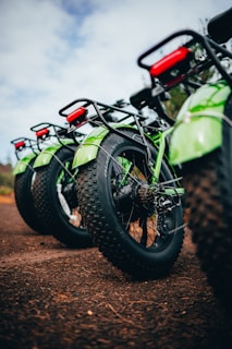 a green motorcycle parked on dirt