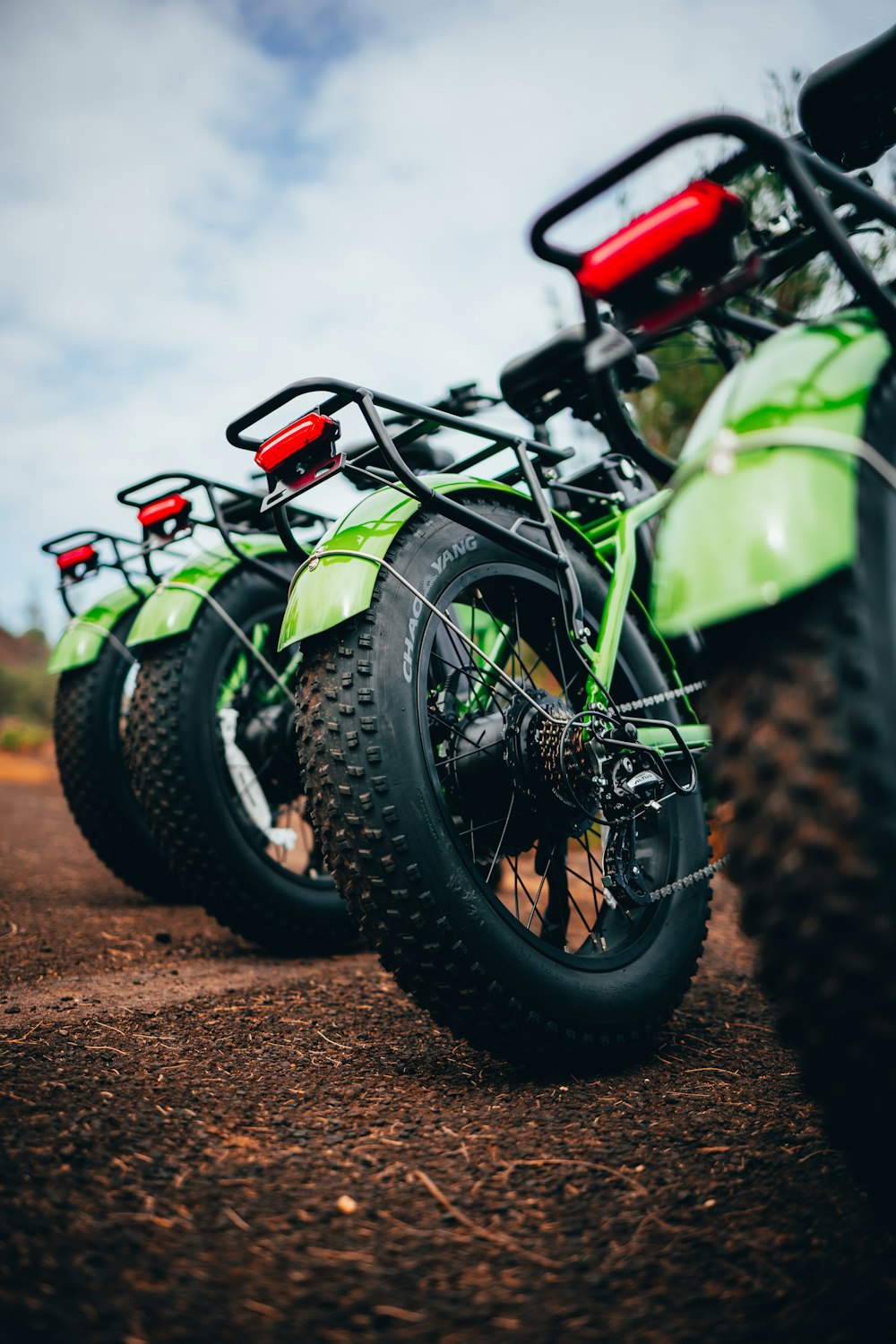 a green motorcycle parked on dirt