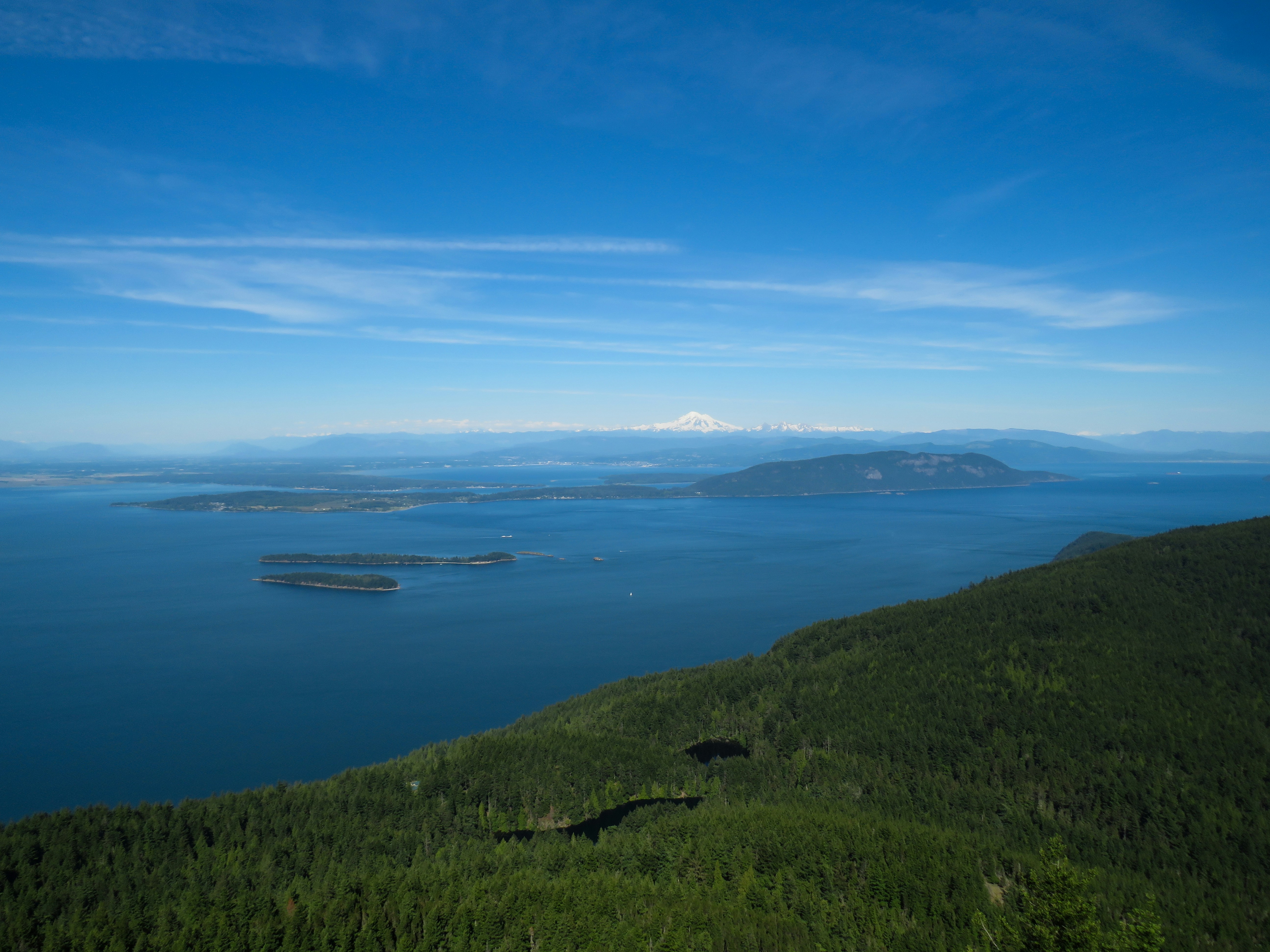 Grassy hilltop on Orcas Island offering panoramic views of the Salish Sea. (Photo by David Lang on Unsplash)