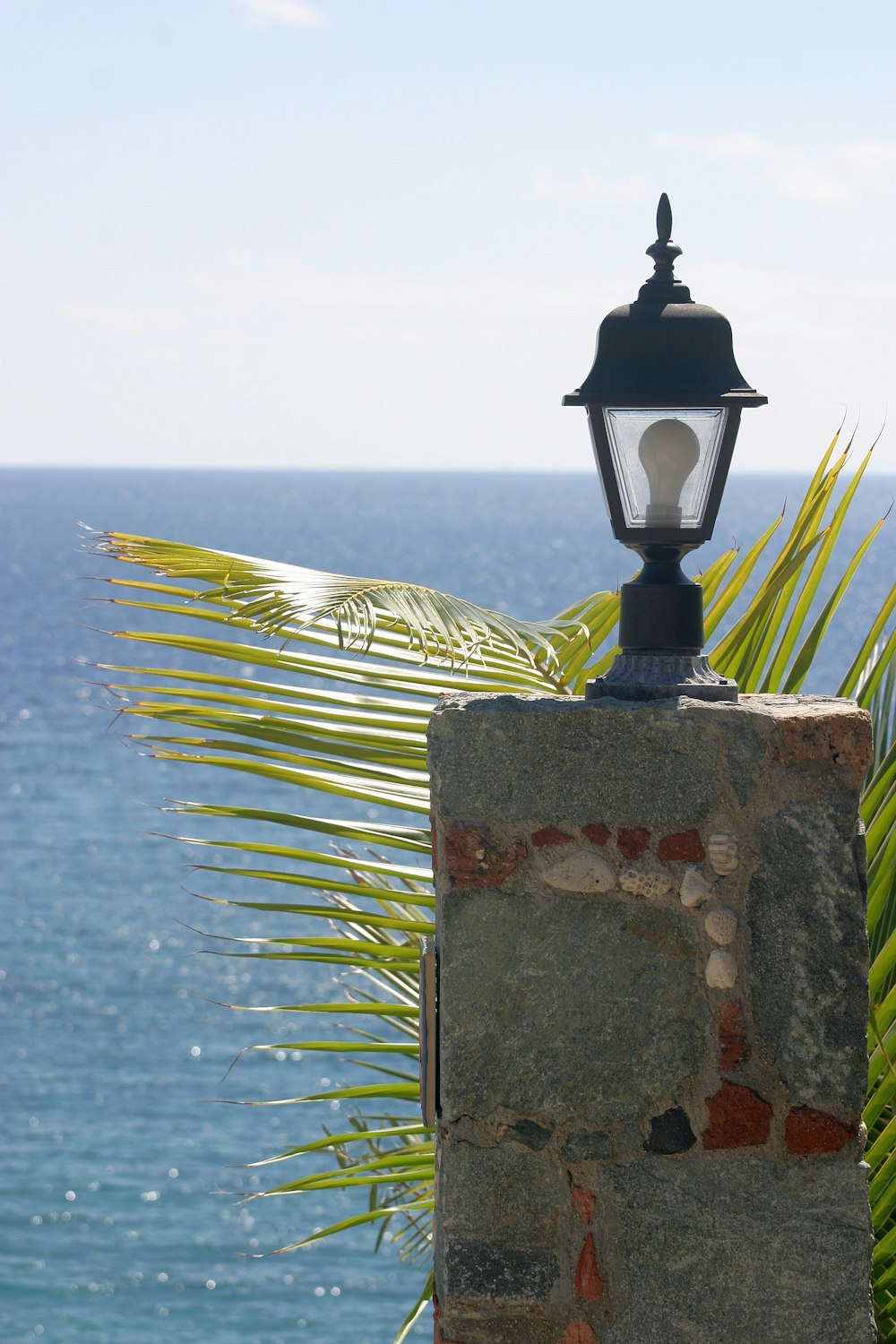 a lamp post on a stone wall