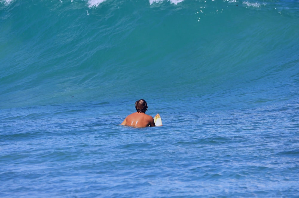 um homem na água com uma prancha de surf