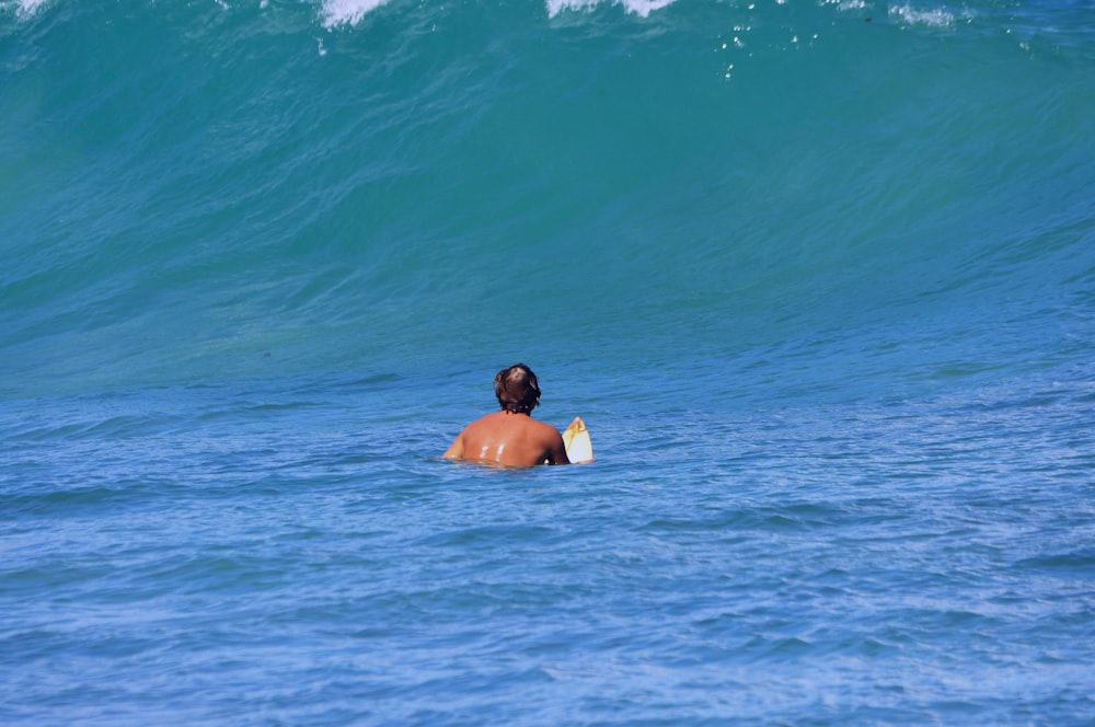 Un hombre en el agua con una tabla de surf