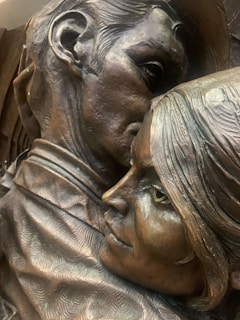 A couple’s 3D sculpture, holding hands and sharing a tender moment with lifelike expressions.