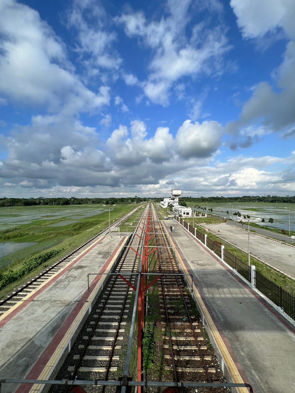 train tracks with grass and trees on either side of them