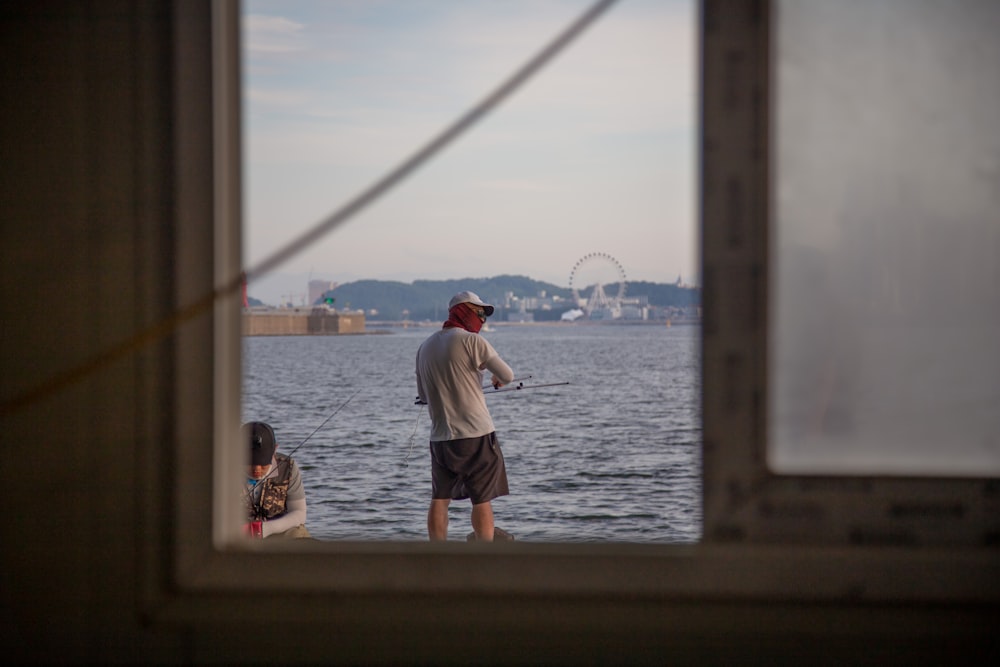 a man standing on a dock looking out at a body of water