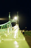 A nighttime shot of a lit bridge highlighting its structural design.