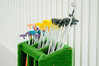 A set of colorful golf balls arranged neatly on a wooden tee holder