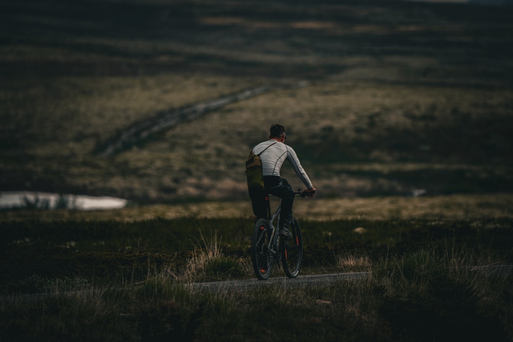 a person riding a bicycle on a dirt road