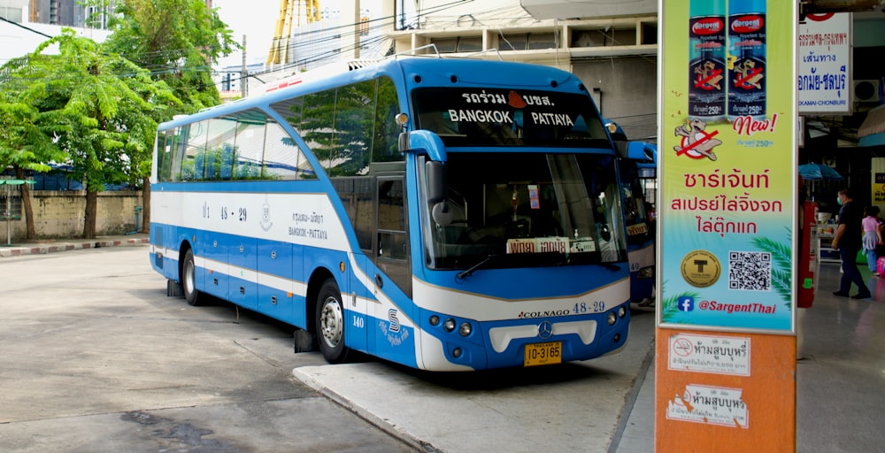 a blue bus parked on the side of a street