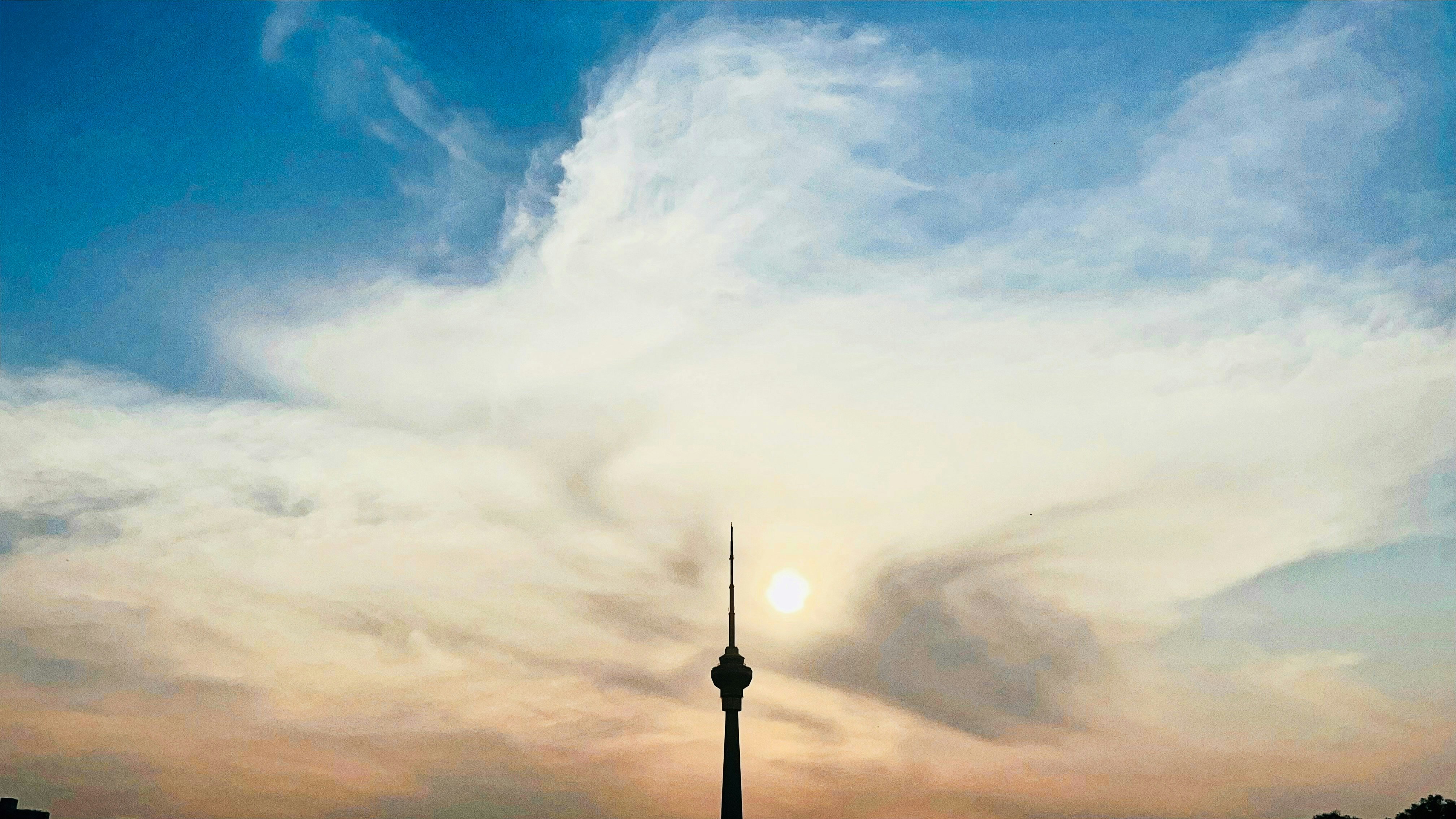 a tall tower with a cloudy sky - Beijing