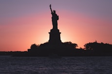 a large statue in front of a sunset