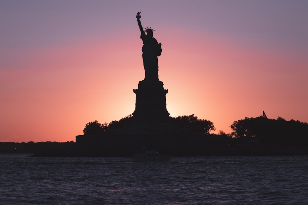 uma grande estátua em frente a um pôr do sol