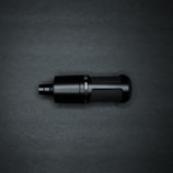 A black cylindrical microphone with a mesh pattern on its body sits against a dark background. The microphone has a sleek, modern design with a matte finish and visible text or branding on the side.