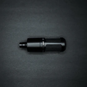 Professional microphone with a dark metallic finish against a black background