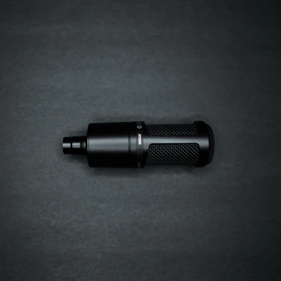 Close-up of the sleek Vaurx Elite K9 dual wireless microphone resting on a dark textured surface, highlighting its premium build.