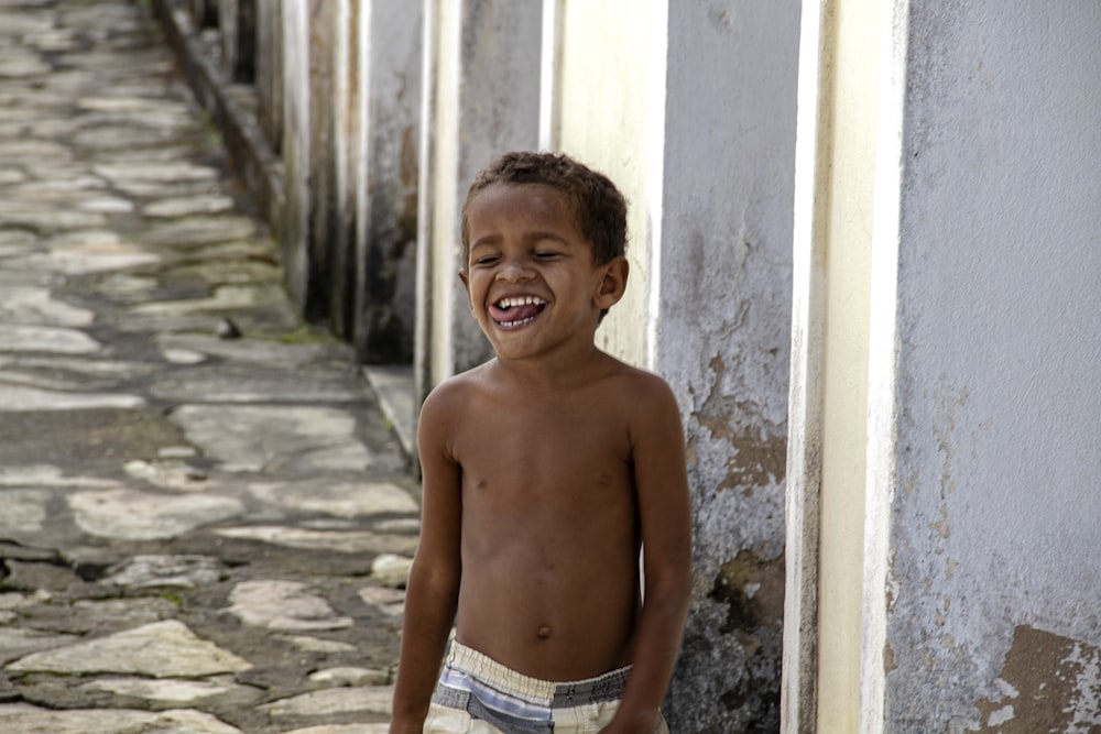 a boy smiling and standing in a stone hallway