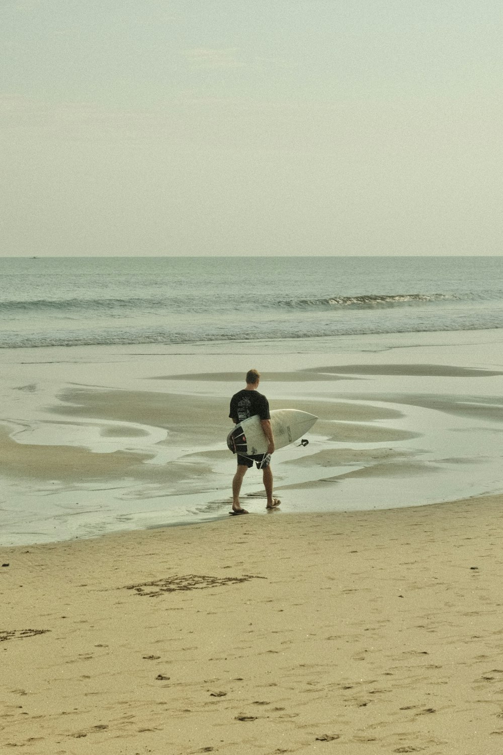 a man standing on top of a sandy beach